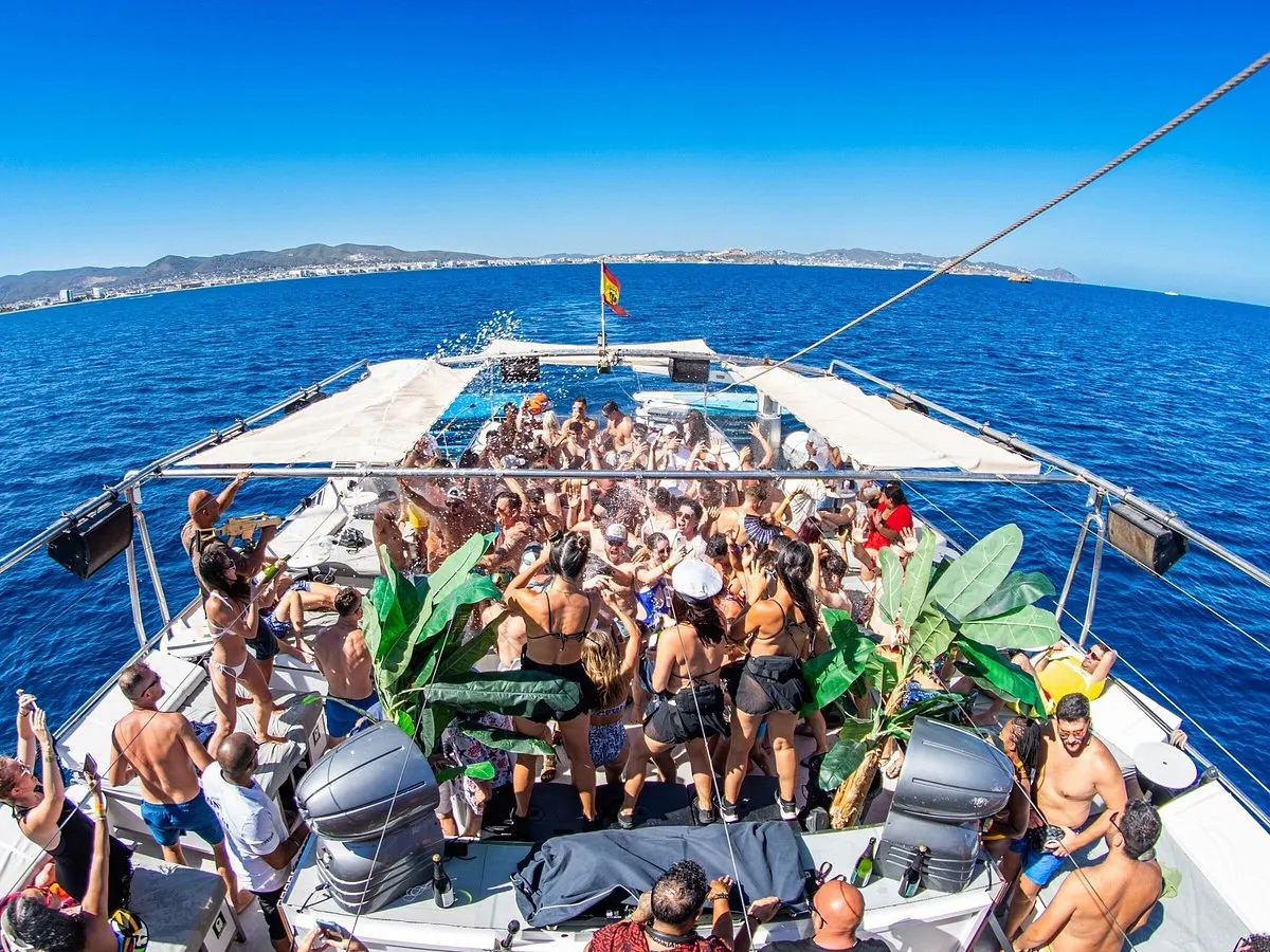 Ibiza cruising boat party with people enjoying music, sea views, and a sunny cruise.