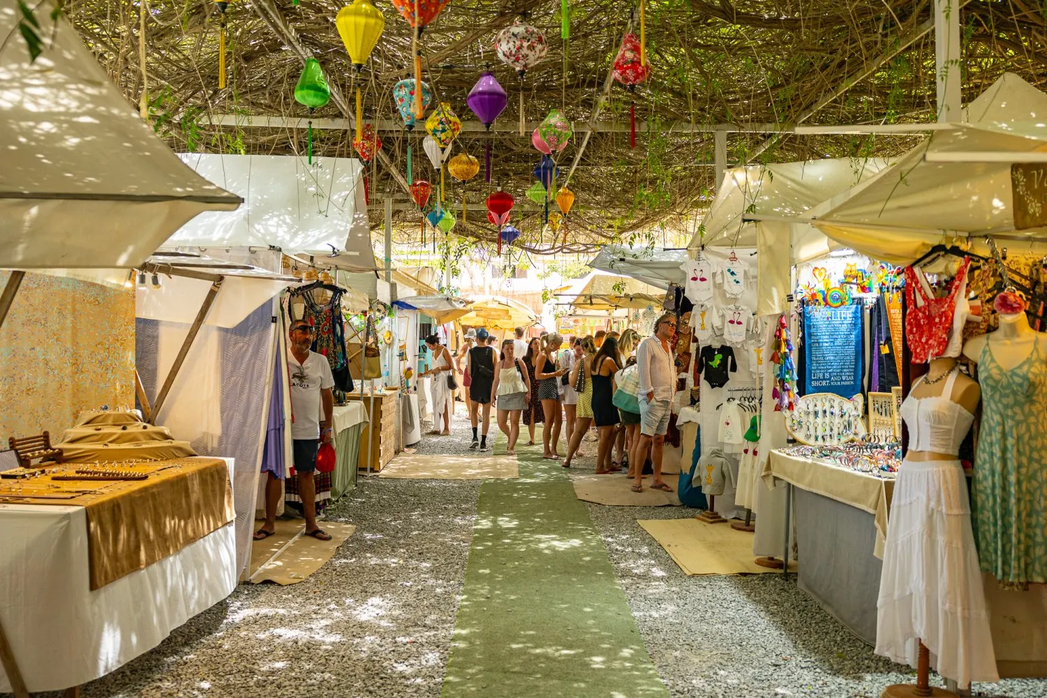 Las Dalias Market in Ibiza with colorful stalls, handmade crafts, and visitors exploring.